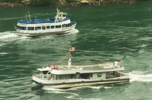 Канадский катер Hornblower с 6 пассажирами на борту и американский Maid of the Mist, везущий несколько сотен туристов к Ниагарскому водопаду во время пандемии covid-19